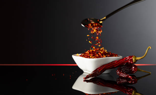 istock Red pepper flakes pour in white bowl. 2163139637