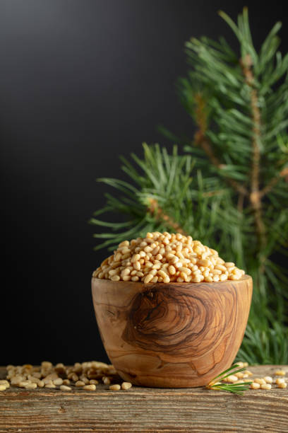 istock Peeled pine nuts and cedar branch on a old wooden table. 2163139665