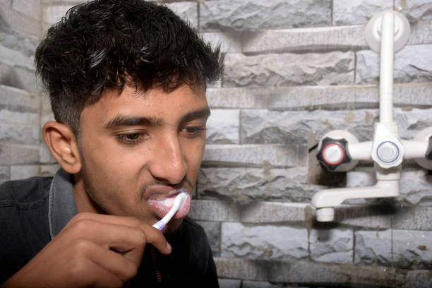 a boy Brushing Teeth In Bathroom ,black shirt