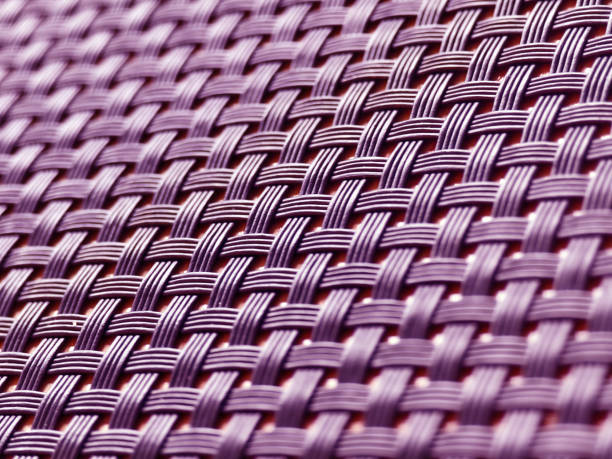 A closeup view of a wicker mat placed on a wooden table.