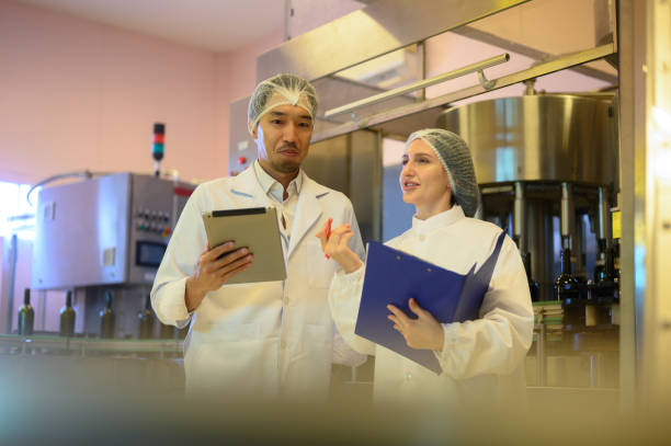 istock Wine production engineers work in the beverage industry in large modern wineries and test wines in winery warehouses. 2163149325