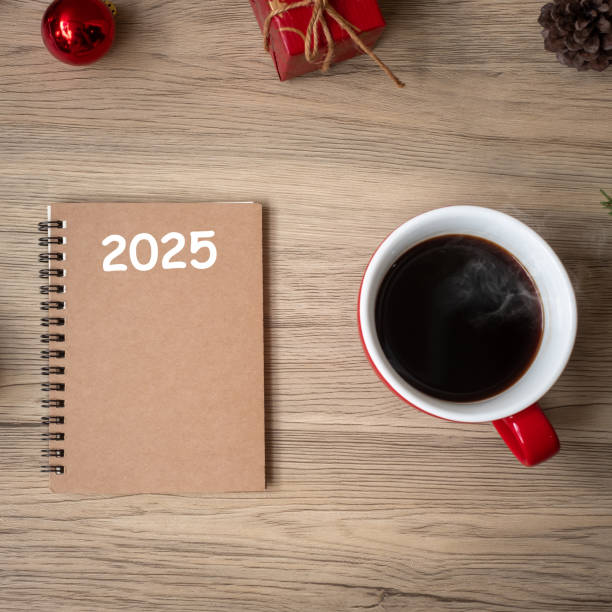 istock 2025 notebook, black coffee cup and Christmas gift on wood table, Top view and copy space. Xmas, Happy New Year, Goals, Resolution, To do list, Strategy and Plan concept 2163150896