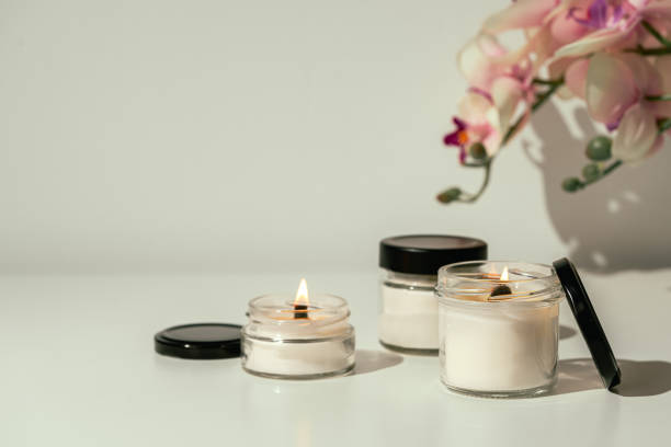 istock Burning Candles With Pink Orchid Flowers on White Surface 2163153096
