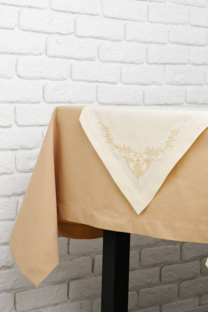 istock Beige Tablecloth on Wooden Table With White Brick Wall Background 2163155638