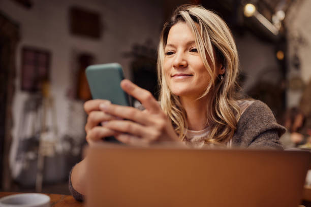 istock Smiling woman using wireless technology in a restaurant. 2163156774