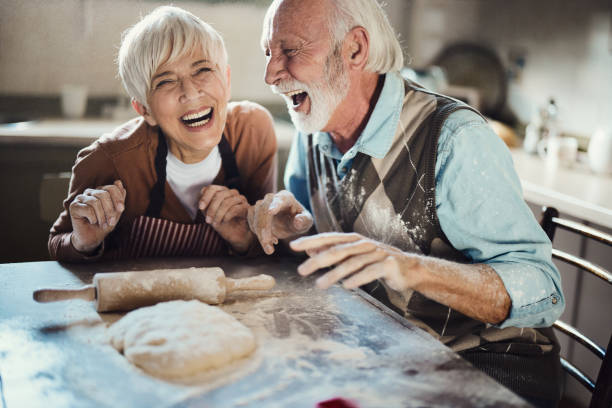 istock Cheerful mature couple having fun while making a cake in the kitchen. 2163157004