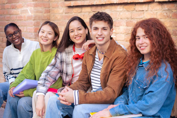 istock Multiethnic group of happy and smiling students with notebooks looking at camera 2163157257