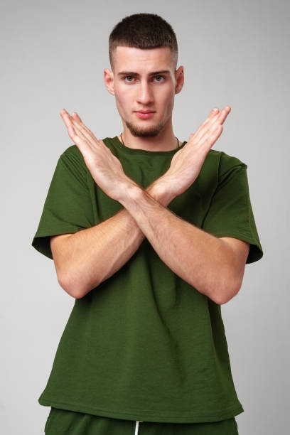 istock Young Man Making a Stop Gesture in a Green T-Shirt 2163158421