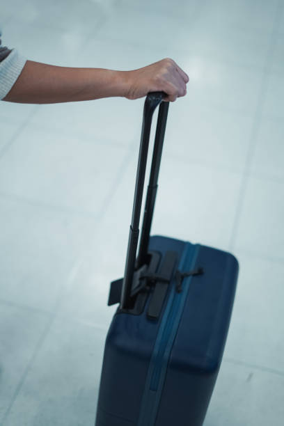 istock Female hand holding a suitcase 2163160650