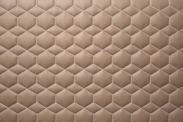 Leather stitched hexagon or honeycomb and diamond shape pattern, Beige shiny texture or background with bumps