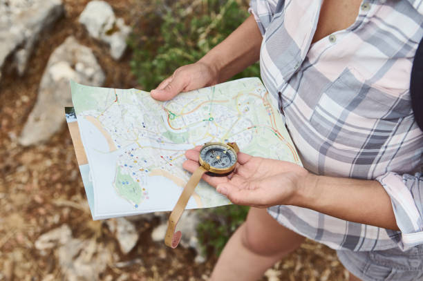 istock Woman using compass and map for navigation during outdoor hike 2163166681