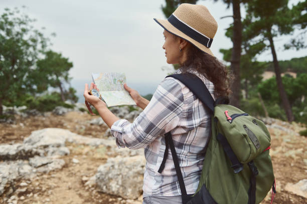 istock Woman hiking in nature with a backpack, using a map and compass for navigation 2163166802