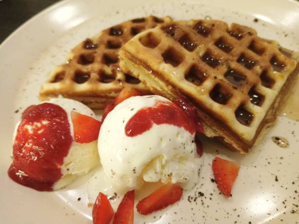 istock delicious waffle with ice cream and strawberry syrup. 2163168805