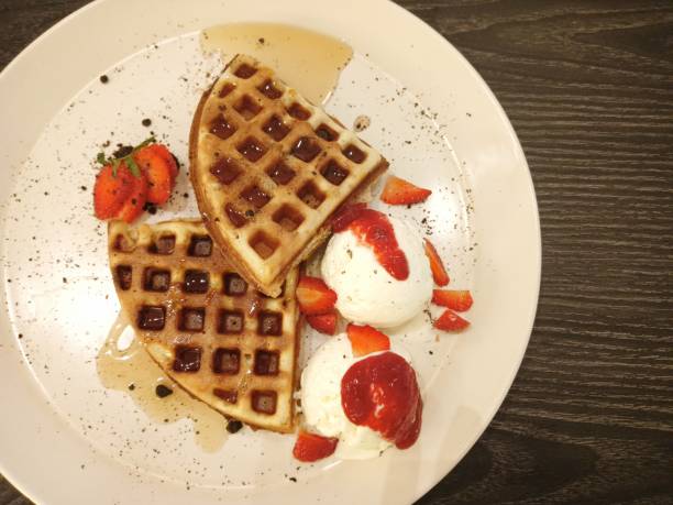 top of view of waffle with ice cream and strawberry syrup.