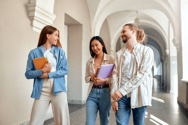istock Three college students walk together, sharing laughter and friendship while exploring the campus 2163170307