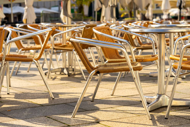 istock Many wicker chairs at cafe tables in the morning sun 2163170420