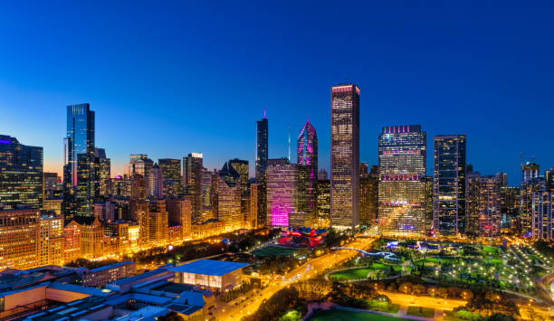 Aerial of the Downtown Chicago Loop at dusk with Millennium Park in the foreground.