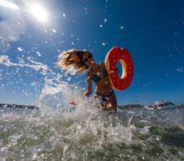 istock Woman Having Fun in Shallow Beach Water 2163175354
