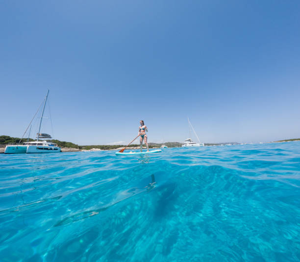 istock Woman Paddleboarding in Clear Blue Sea 2163175449