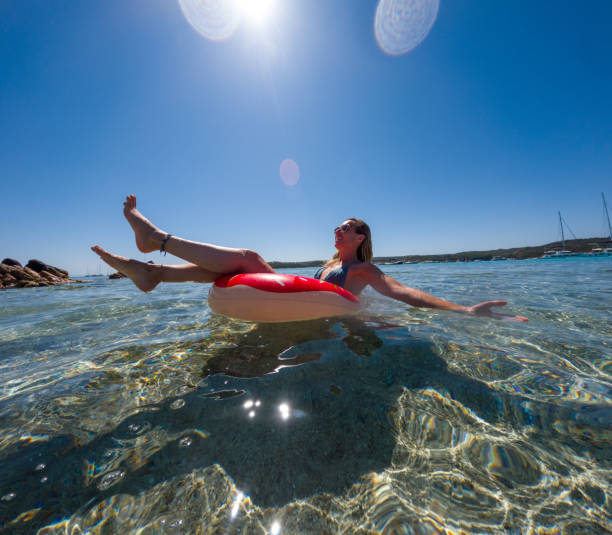 istock Woman Relaxing on Inflatable Ring in Clear Water 2163176044