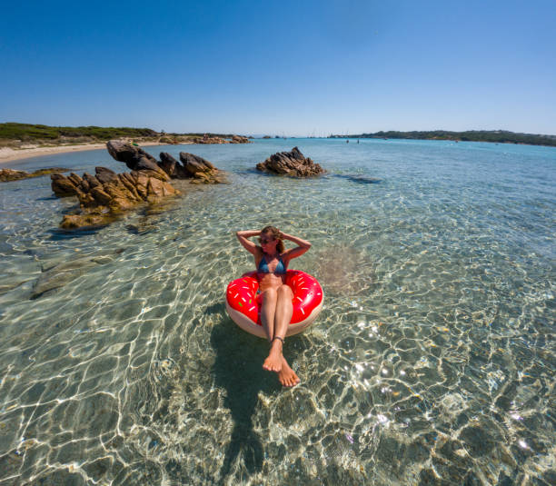 istock unny Beach Scene: Woman Floating on Inflatable Ring in Clear Water 2163176216
