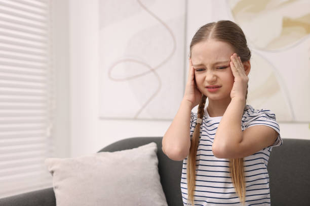istock Little girl suffering from headache on sofa indoors. Space for text 2163176660