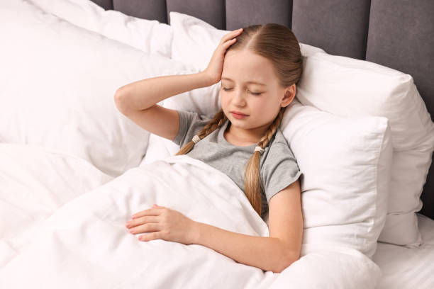 istock Little girl suffering from headache in bed 2163176744