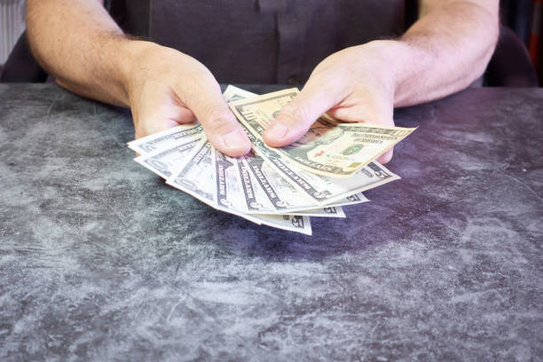 istock Man hands showing dollar bills on the table 2163178480