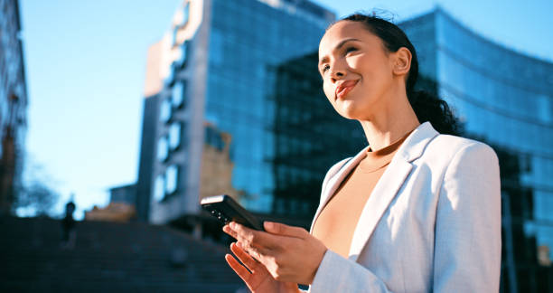istock Confident Young Businesswoman Using Smartphone Outside Modern Office Building 2163179693