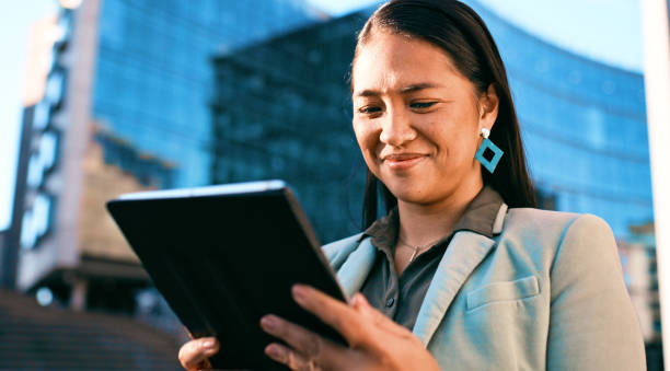 istock Confident Businesswoman Using Tablet Outside Modern Office Building 2163179722