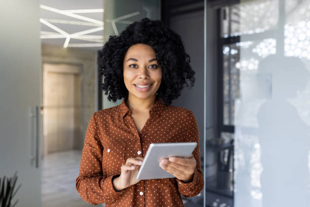 istock Smiling woman using digital tablet in modern office environment 2163180220