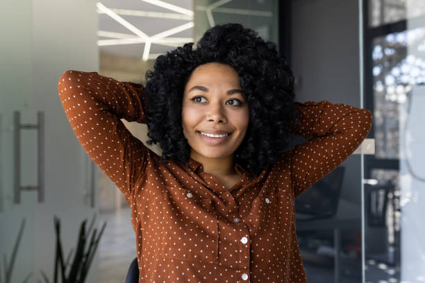 istock Confident young woman smiling in a modern office setting 2163181413