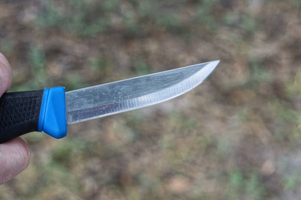 istock hand holds a gray knife with a black handle 2163183493