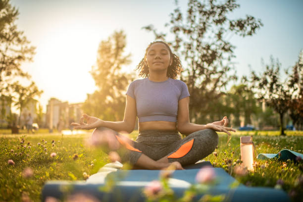 Young woman practicing yoga in a summer park