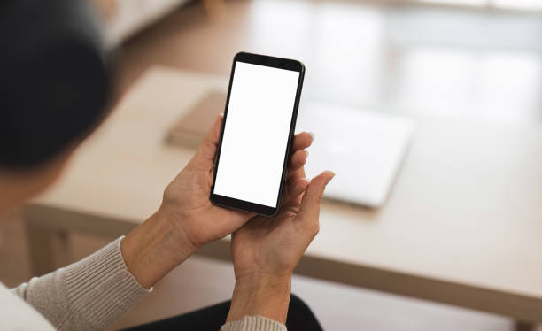 istock Woman holding a phone with a blank white screen 2163187022