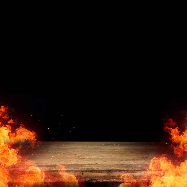istock Fire flames isolated on wooden table and black wall background, copy space for products. 2163187456
