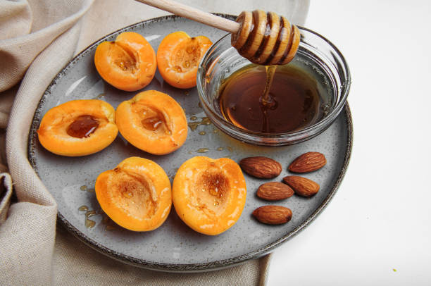 istock Apricots on plate with bowl of honey 2163187821