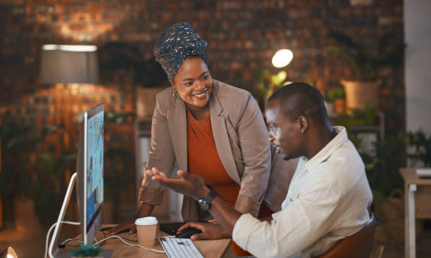 istock Business people, computer working and night project with mentor and collaboration discussion of website design. Conversation, African staff and communication for online work and planning at office 2163189334