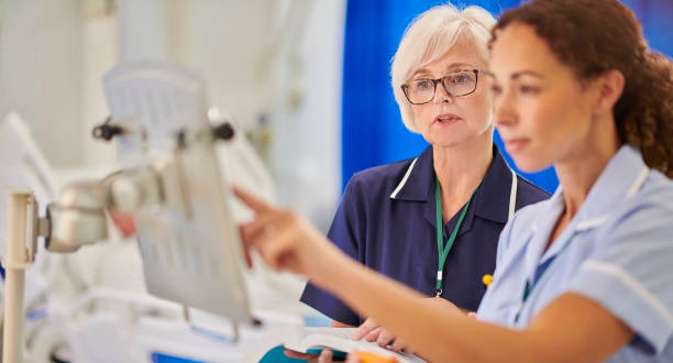 senior staff nurse supervising medicine dosages stock photo