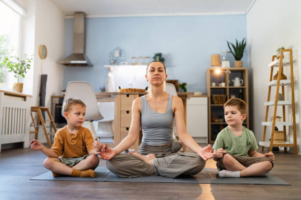 istock Mother and her two sons practicing yoga at home 2163195245