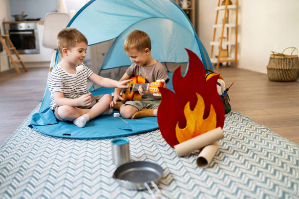 Two little brothers camping inside their home.