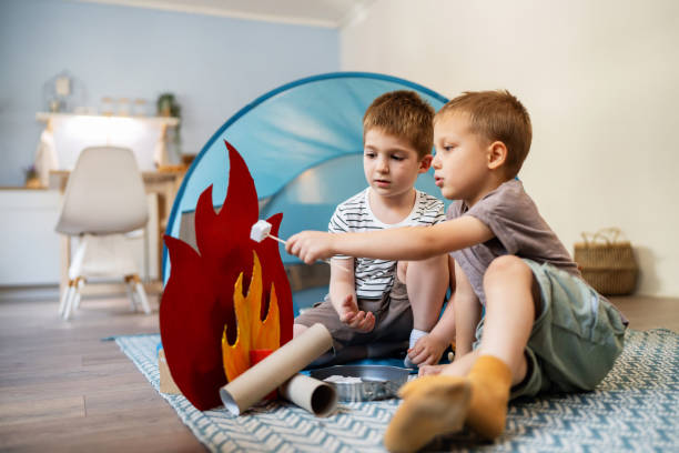 Two little brothers camping inside their home.