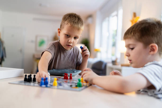 istock Kids playing ludo game at home 2163196947