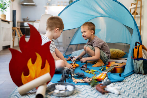 Two little brothers camping inside their home.