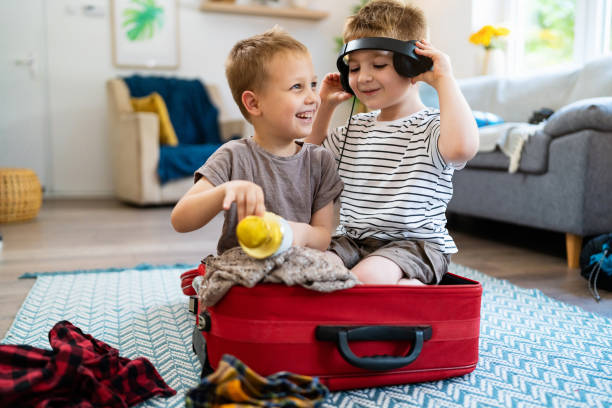 istock Two little brothers playing while packing suitcase for the trip 2163197742