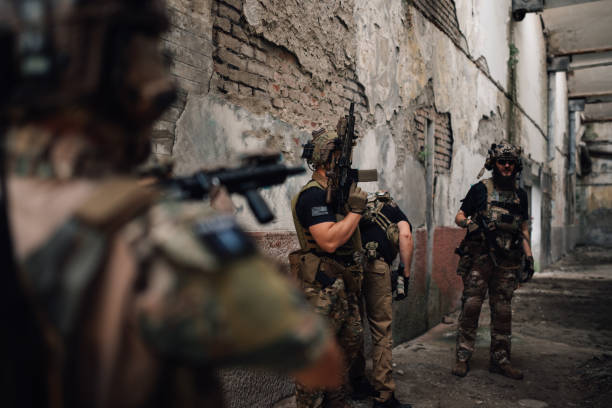 istock Group of airsoft players with guns simulating war at abandoned facility 2163204979