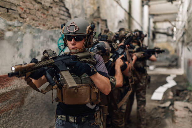 istock Group of armed troops in camouflage uniforms having action at warzone. 2163205018