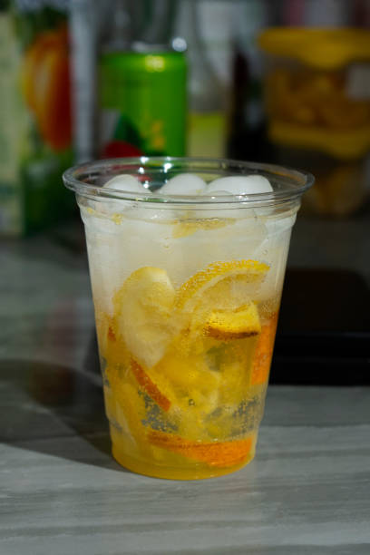 istock Cold lemonade with ice and fresh citrus pieces in a transparent plastic glass. 2163206530