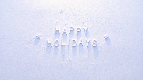 White letters spelling phrase Happy Holidays arranged on white textured snowy background in sunlight