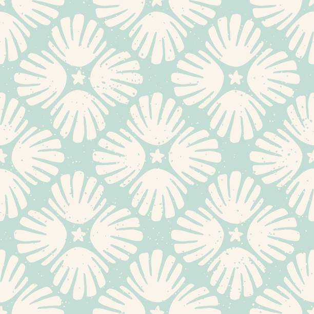 Pastel blue sea shells block print seamless pattern with speckled texture. Diagonal tile pattern with seashells and stars in light blue and cream. Vintage summer holiday textured background.
